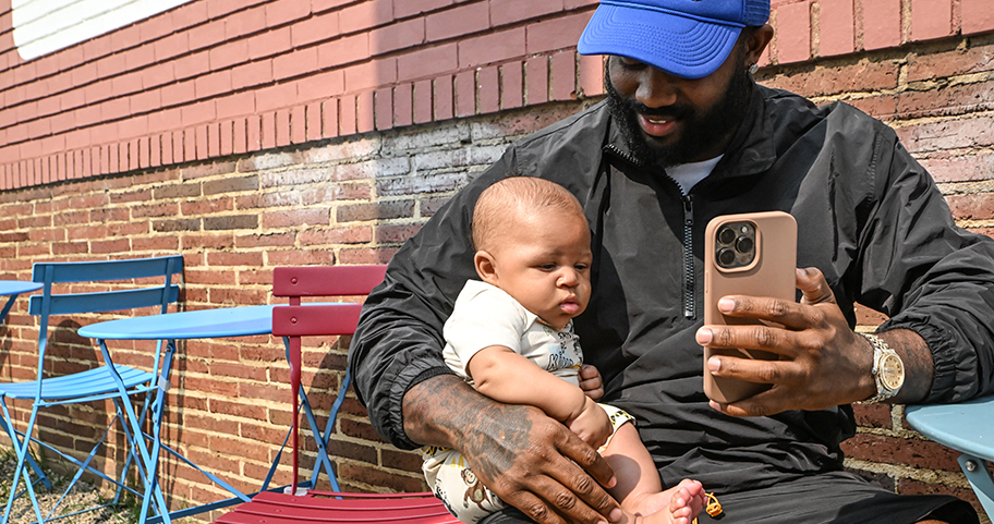 A father and his newborn sitting outside at a local restaurant. 